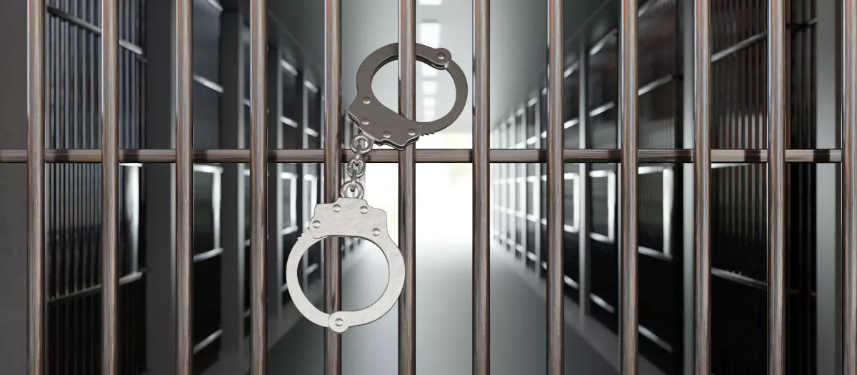 handcuffs-on-jail-cell-closed-metal-bar-door-prison-building-corridor-background-3d-render965751