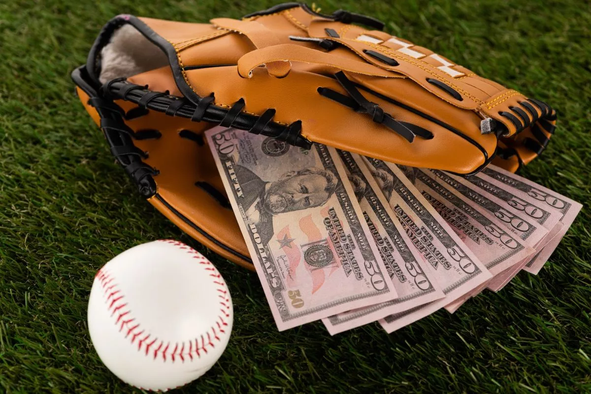 dollar-banknotes-in-baseball-glove-near-ball-on-green-grass-sports-betting-concept134924