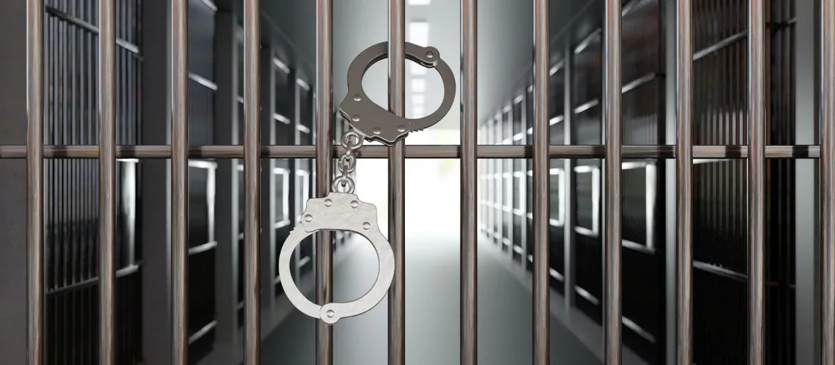 handcuffs-on-jail-cell-closed-metal-bar-door-prison-building-corridor-background-3d-render910401