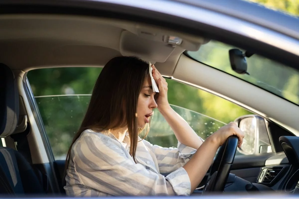 woman-driver-being-hot-during-heat-wave-in-car-suffering-from-hot-weather-wipes-sweat-from-forehead305200