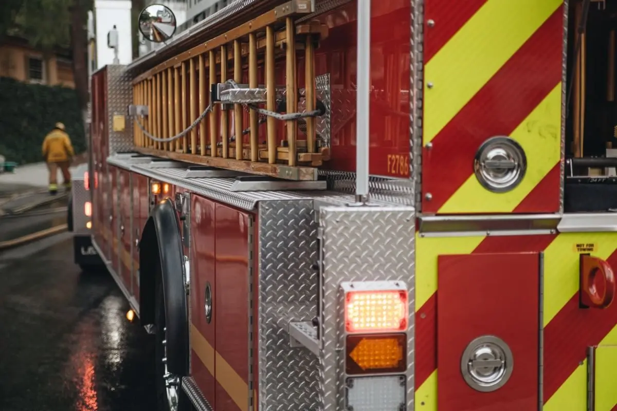 back-and-side-of-a-fire-truck-responding-to-a-fire-with-a-firefighter-in-the-background545440
