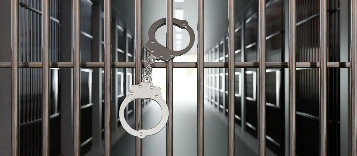 handcuffs-on-jail-cell-closed-metal-bar-door-prison-building-corridor-background-3d-render887908