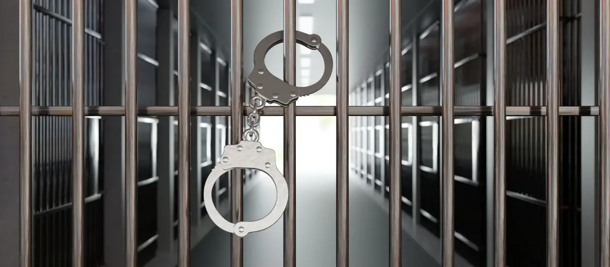 handcuffs-on-jail-cell-closed-metal-bar-door-prison-building-corridor-background-3d-render93486