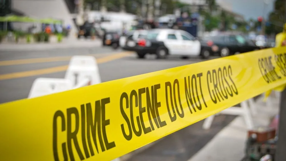 crime or accident scene sign do not pass the line with police cars in the background