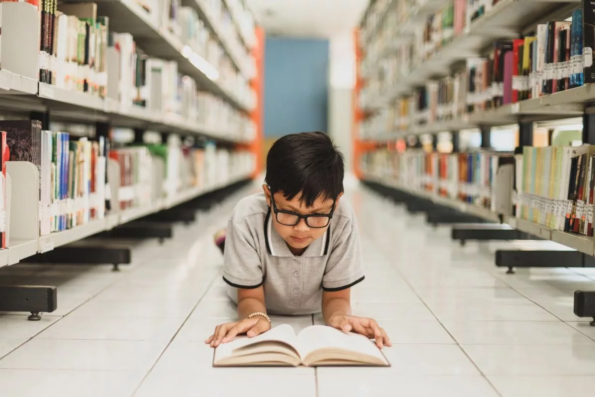 smart-school-boy-reading-a-book-at-the-library977277