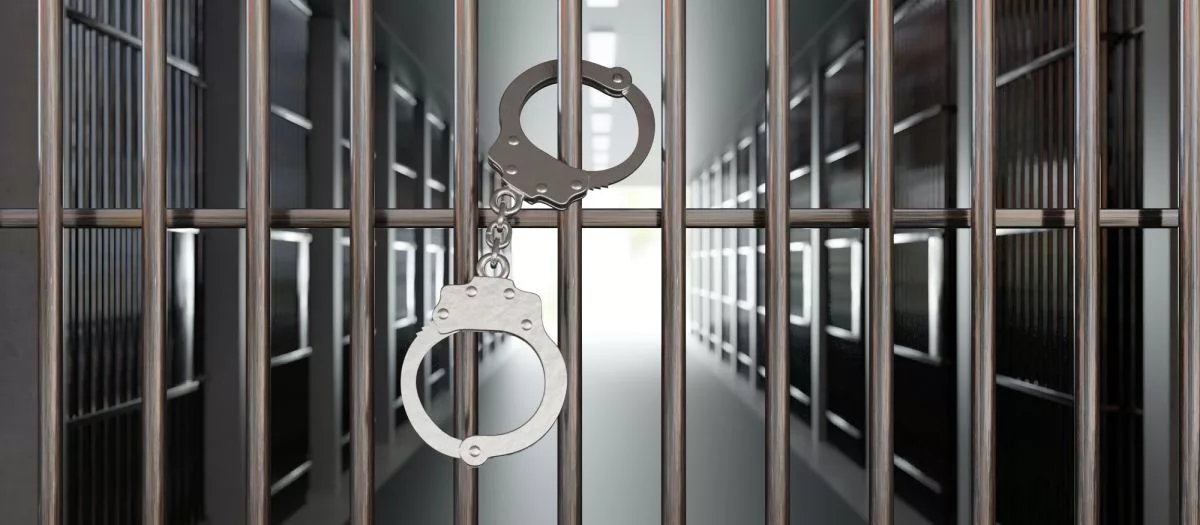handcuffs-on-jail-cell-closed-metal-bar-door-prison-building-corridor-background-3d-render654034