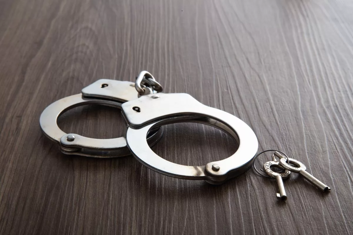 police-metal-handcuffs-on-dark-wooden-background401708
