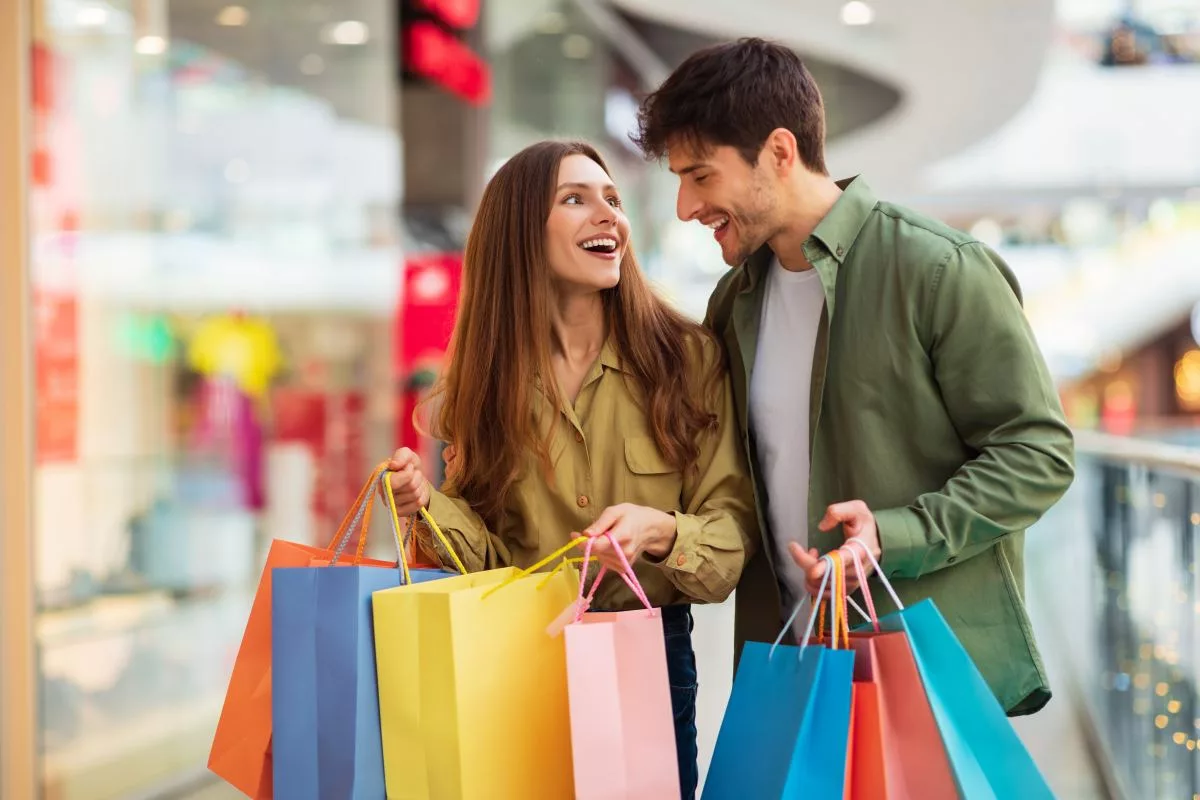 joyful-couple-on-shopping-laughing-holding-shopper-bags-in-hypermarket105579