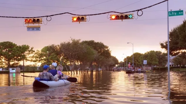 Working traffic lights over flooded Houston streets and boats with people at sunset. Texas^ USA