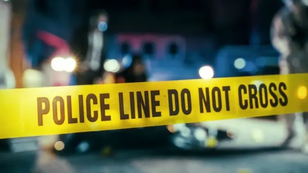 Yellow Tape Showing Text "Police Line Do Not Cross" Restricting a Crime Scene Area At Night. Close Up Aesthetic Shot with Bokeh Effect and Flickering Lights. Criminal on the Loose Strikes Again