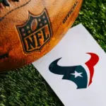 Houston Texans NFL team Logo and American football ball on Green Grass. HOUSTON^ USA^ FEBRUARY 10^ 2025