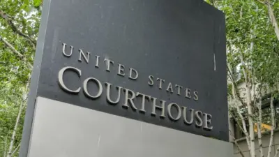 The United States Courthouse sign stands tall amidst a serene backdrop of trees at the US District Court in Seattle^ Washington. Seattle - May 17^ 2019: