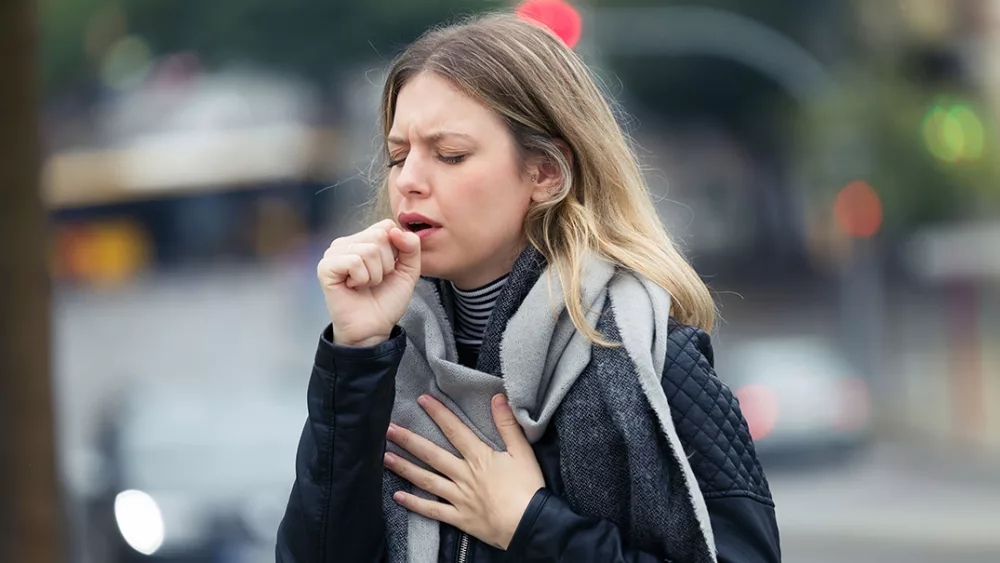 desktop_young-woman-coughs-coughing-in-the-street_gettyimages-1076823284