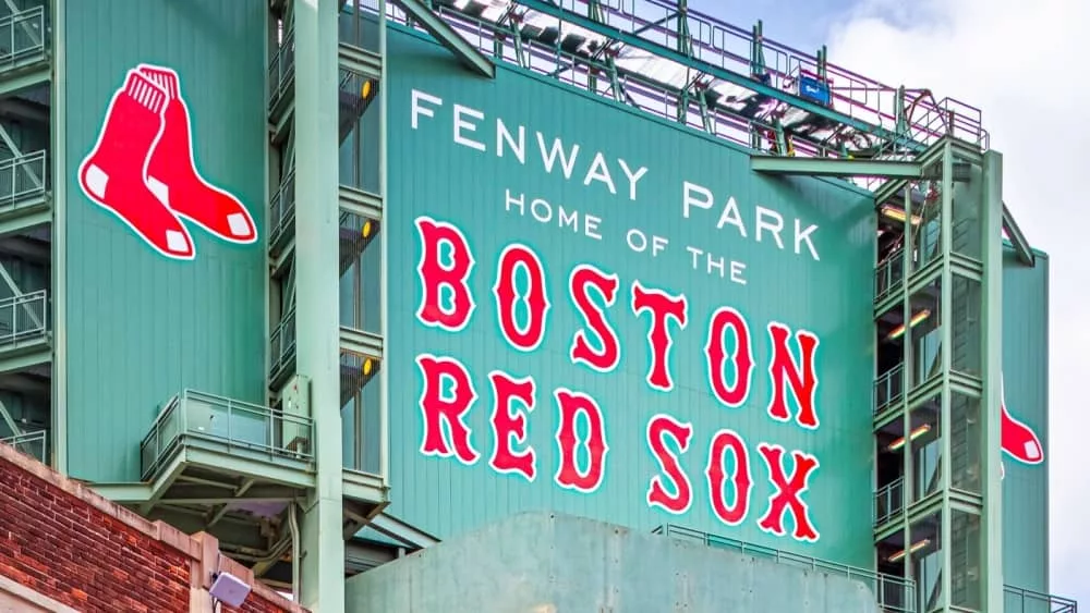 view of the historic architecture of the Famous Fenway Park Stadium in Boston^ MA^ USA showcasing its huge sign^ old brick walls^ and entrances on Lansdowne street. Boston^ MA^ USA - March 1^ 2023