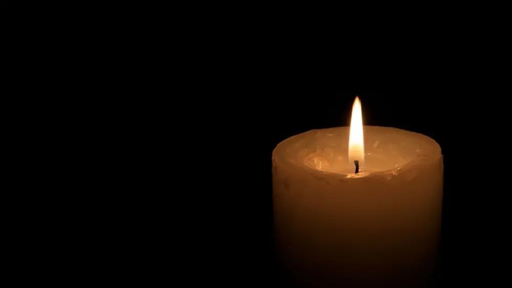 One big burning candles. Bright light on black background. RIP darkness template. Romantic evening on Valentine.