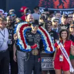 NASCAR: Jack Link: Apr 26, 2026; Talladega, Alabama, USA; NASCAR Cup Series driver Carson Hocevar (77) wears the ceremonial wreath presented by Miss Alabama Emma Terry after his victory at the Jack Links 500 NASCAR Cup Series race at Talladega Superspeedway. Mandatory Credit: Vasha Hunt-Imagn Images