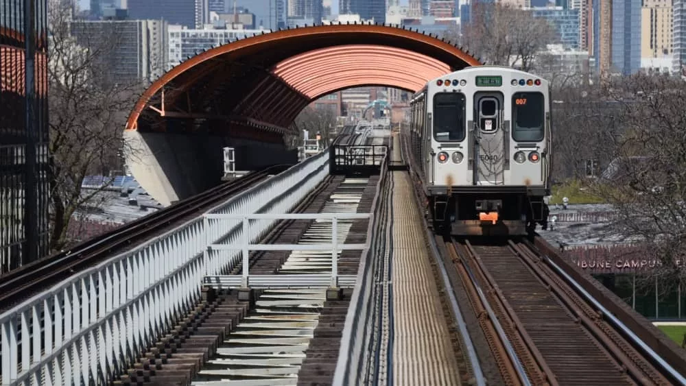 CTA Chicago Transit Authority elevated train tracks with green line train going through the tunnel above the Illinois Institute of Technology McCormick Tribune Campus Cente. Chicago^ IL April 20^ 2020