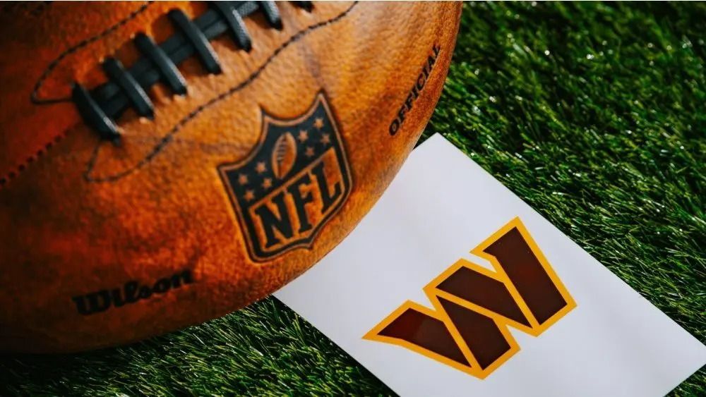 Washington Commanders NFL team Logo and American football ball on Green Grass.