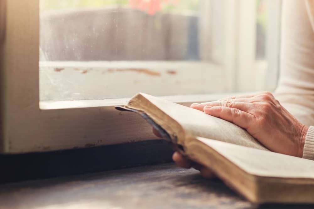 unrecognizable-woman-holding-a-bible-in-her-hands-sbi-305129017