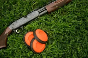 shotgun-and-clay-pigeons-laying-in-grass