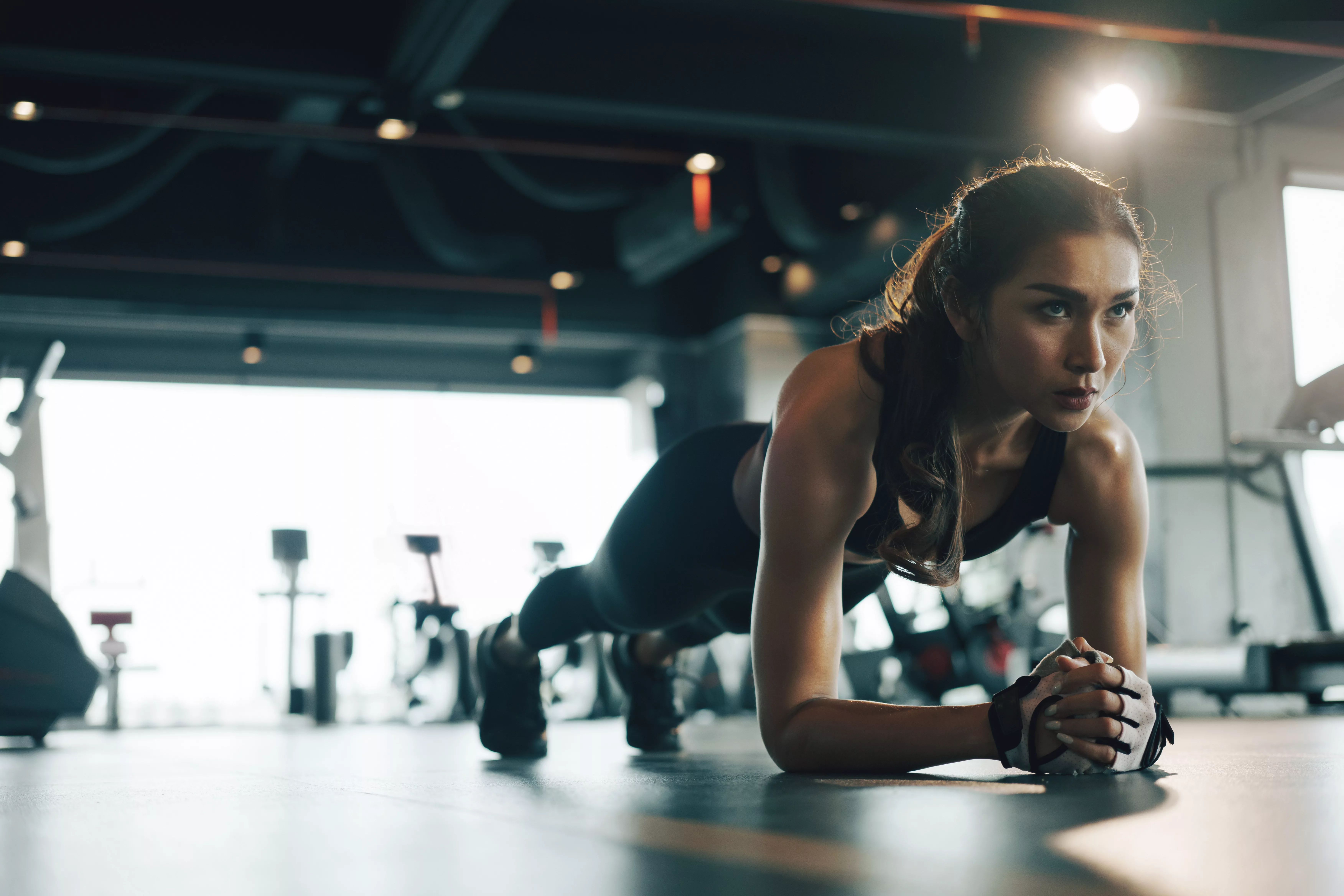 young-woman-doing-plank-exercise-while-exercising-in-gym