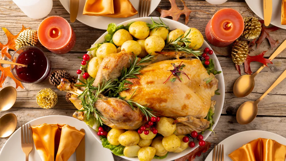 overhead-view-of-thanksgiving-table-with-roast-turkey-vegetables-candles-and-autumn-decoration-thanksgiving-autumn-fall-american-tradition-and-celebration-concept