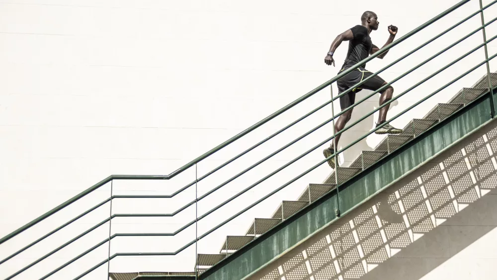 man-in-black-sportswear-running-up-staircase