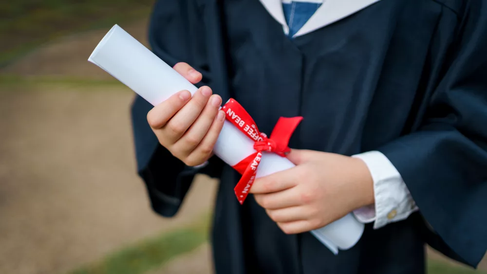 kids-on-graduation-gown-holding-graduation-scroll-2023-11-27-04-53-17-utc