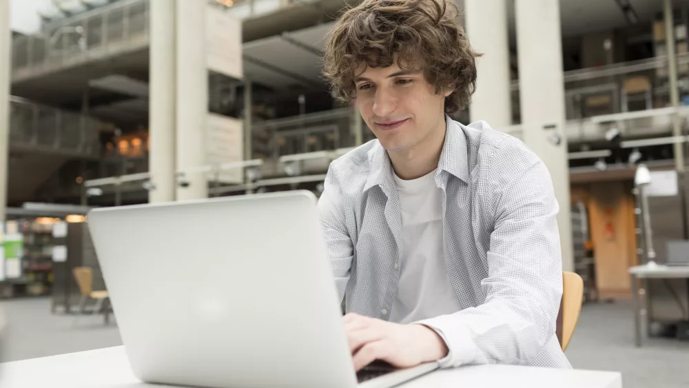 student-using-laptop-in-a-university-library