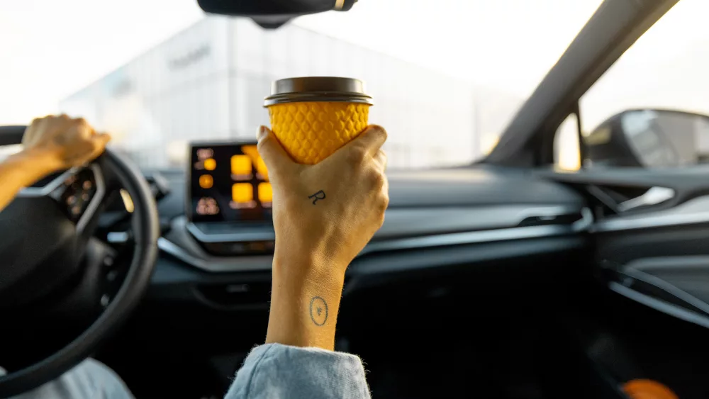 woman-drives-car-with-a-coffee