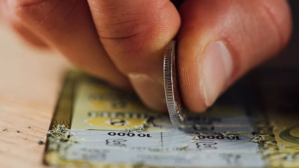 close-up-view-of-hand-of-gambler-stretching-lottery-ticket