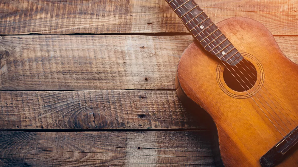 wooden-guitar-close-up-of-guitar-lying-on-vintage-wood-background