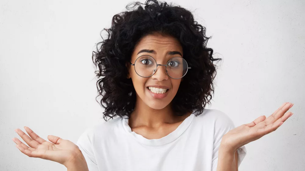 close-up-portrait-of-african-american-female-wearing-white-t-shirt-feeling-guilty-confused-making-helpless-gesture-with-hands-having-oops-expression-on-her-face-human-emotions-and-feelings