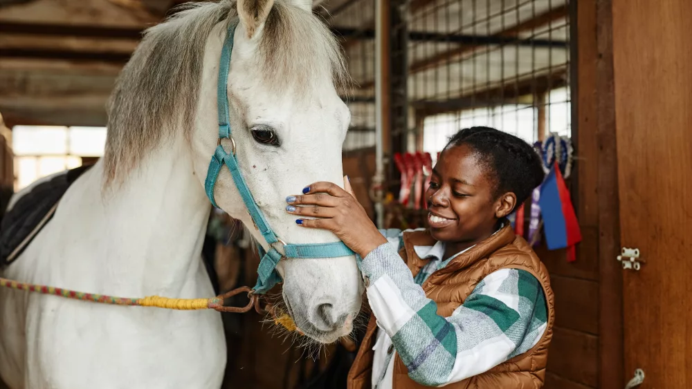 woman-with-white-horse-in-stables