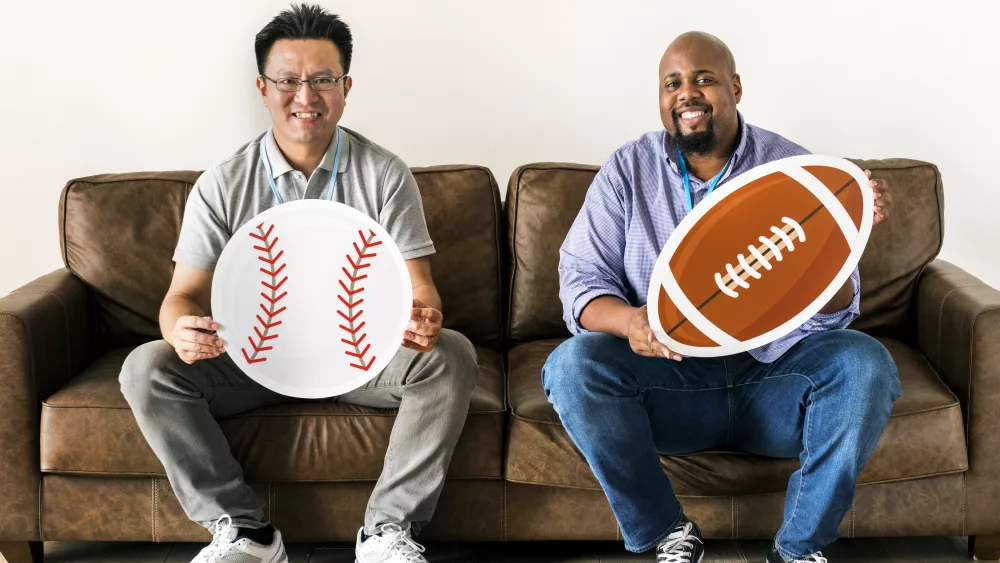 men-holding-baseball-and-rugby-icons-sitting-on-co-2025-02-10-01-22-59-utc