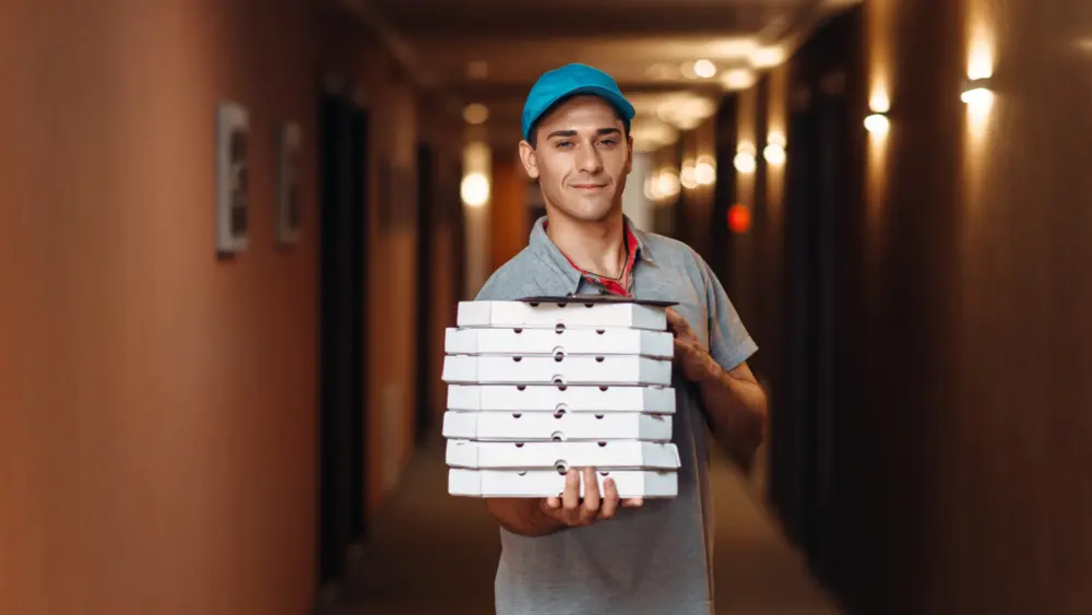 delivery-man-with-fresh-pizza-in-carton-boxes