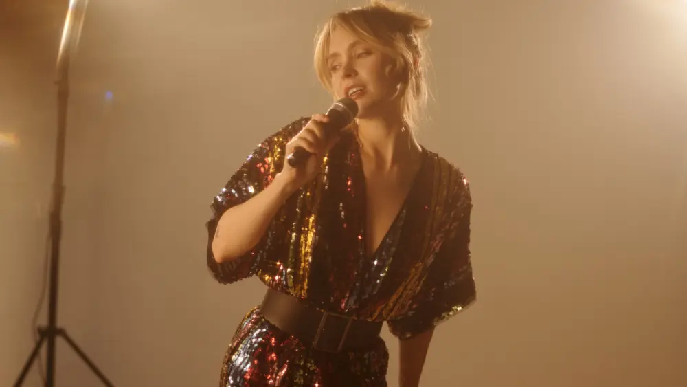 young-actress-singing-into-microphone-during-music-video