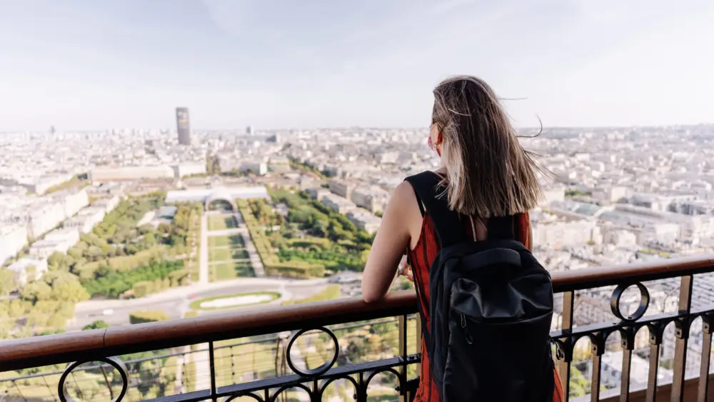 tourist-contemplating-paris-from-the-eiffel-tower