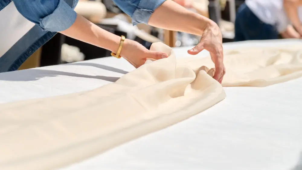 woman-making-holiday-decor-with-tablecloth-on-table