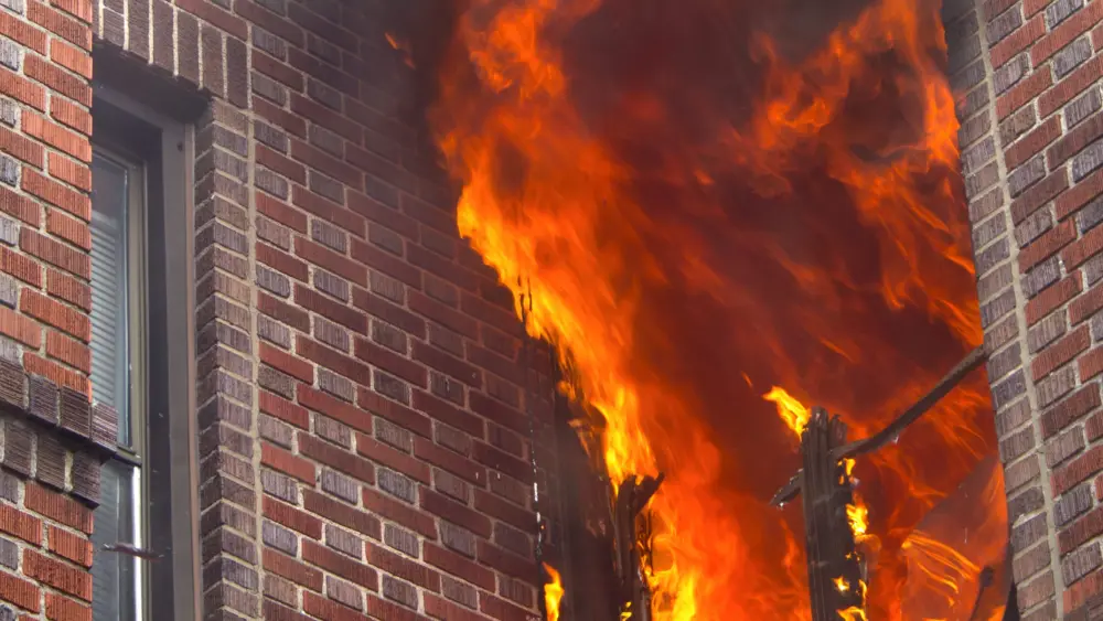 vertical-shot-of-a-burning-apartment-in-a-building-in-the-daylight