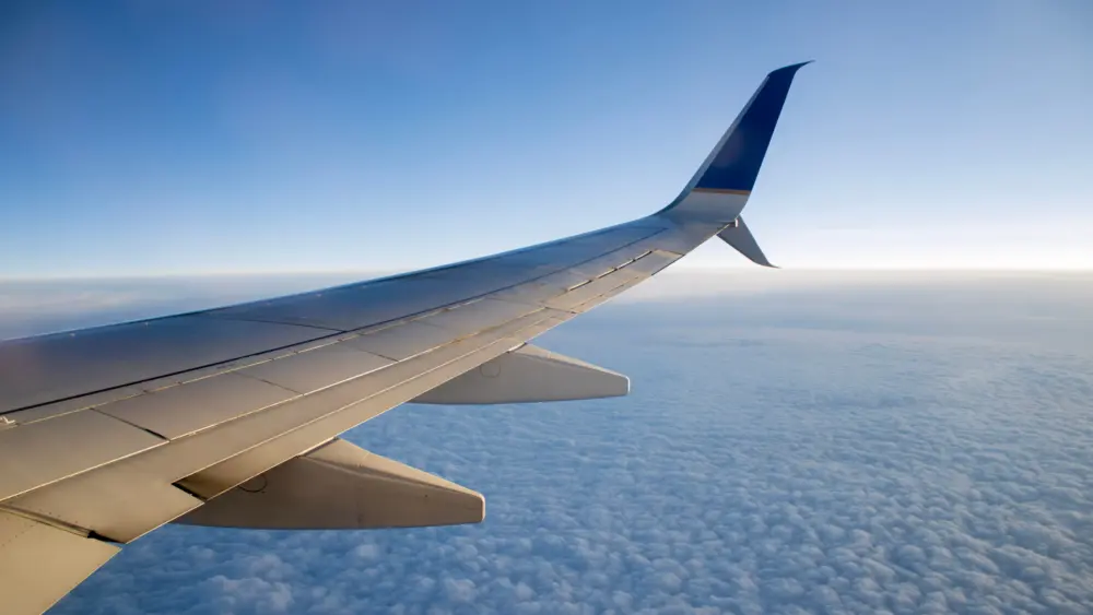 beautiful-shot-of-an-airplane-wing-over-a-layer-of-clouds-in-a-blue-sky