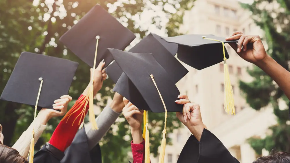 a-group-of-graduates-throwing-graduation-caps-in-the-air