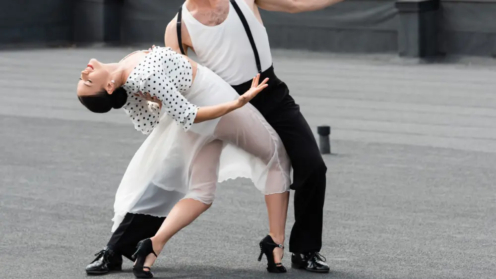 professional-dancer-moving-with-elegant-partner-on-rooftop-of-building-outdoors
