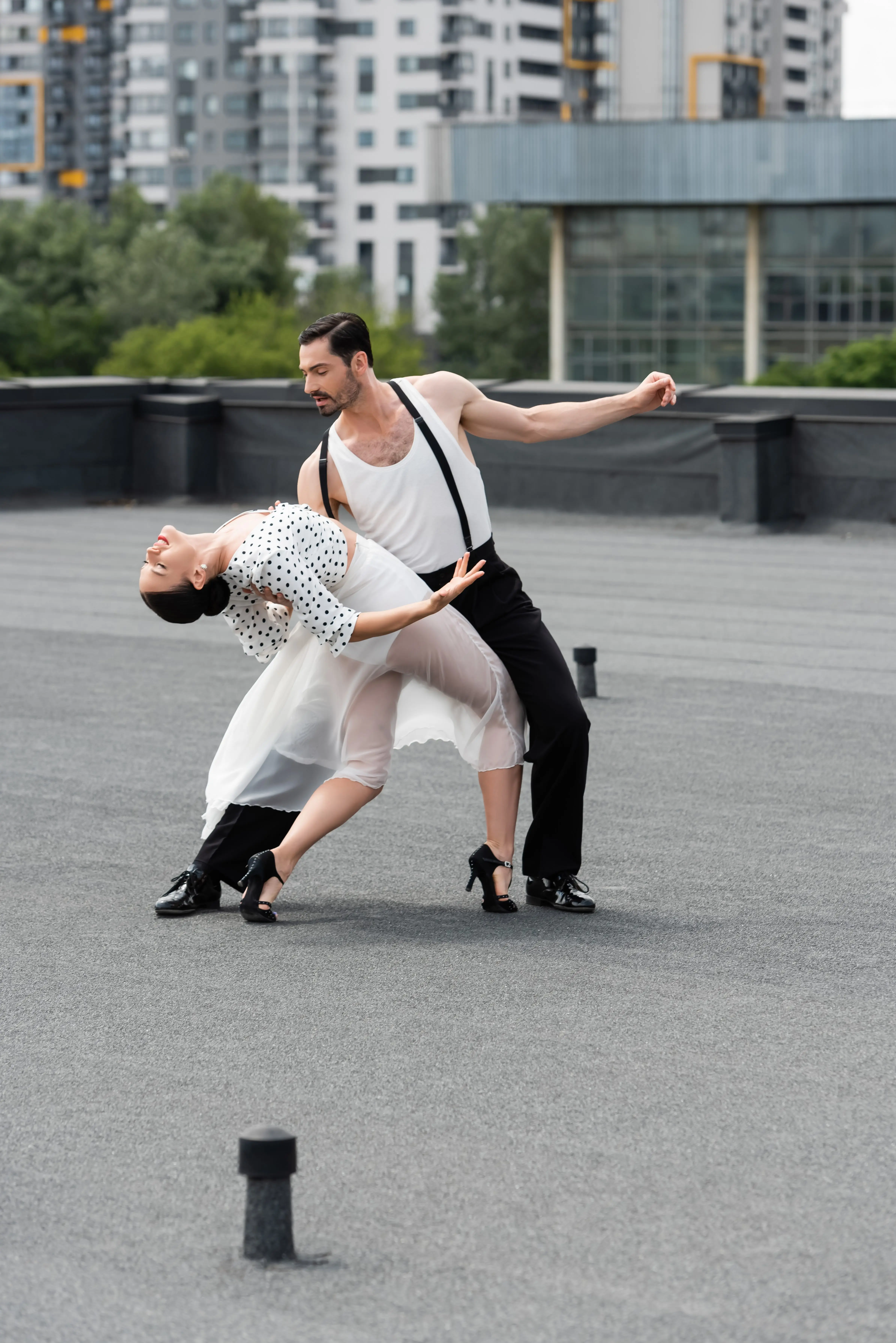 professional-dancer-moving-with-elegant-partner-on-rooftop-of-building-outdoors