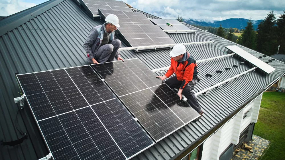 men-workers-installing-solar-panels-on-roof-of-house