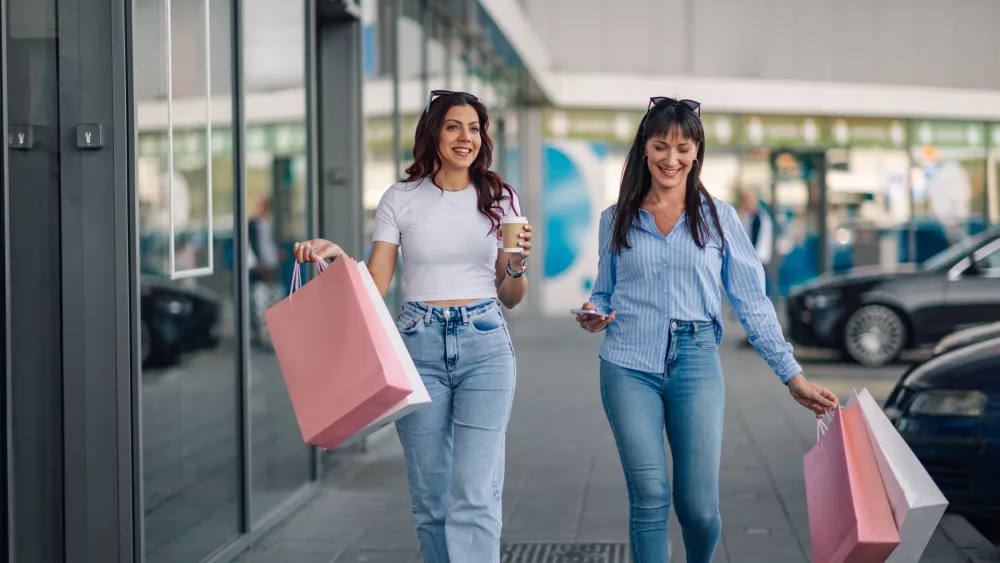 shopper-friends-with-paper-bags-on-shopping-spree-at-shopping-mall