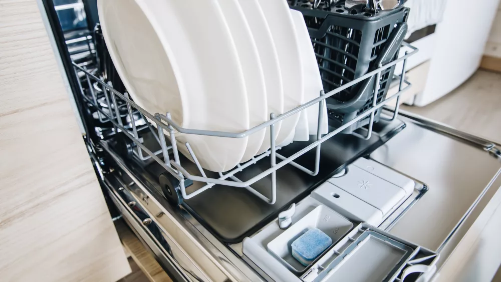 blue-colorful-dishwasher-detergent-tablet-for-dishwashing-machine-open-dishwasher-with-clean-glasses-and-dishes-close-up