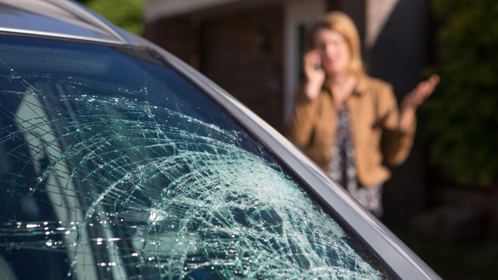 womanphoningforhelpaftercarwindshieldhasbroken