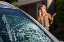 womanphoningforhelpaftercarwindshieldhasbroken