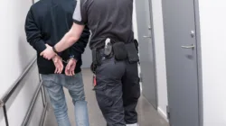 prisonguardescortarrestedinmatethroughjailcorridor